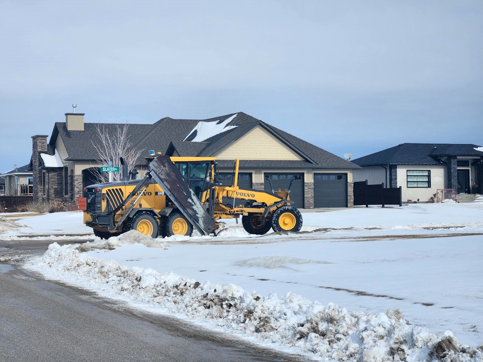 A crew providing residential snow removal services clearing a walkway and driveway in Freehold, NJ